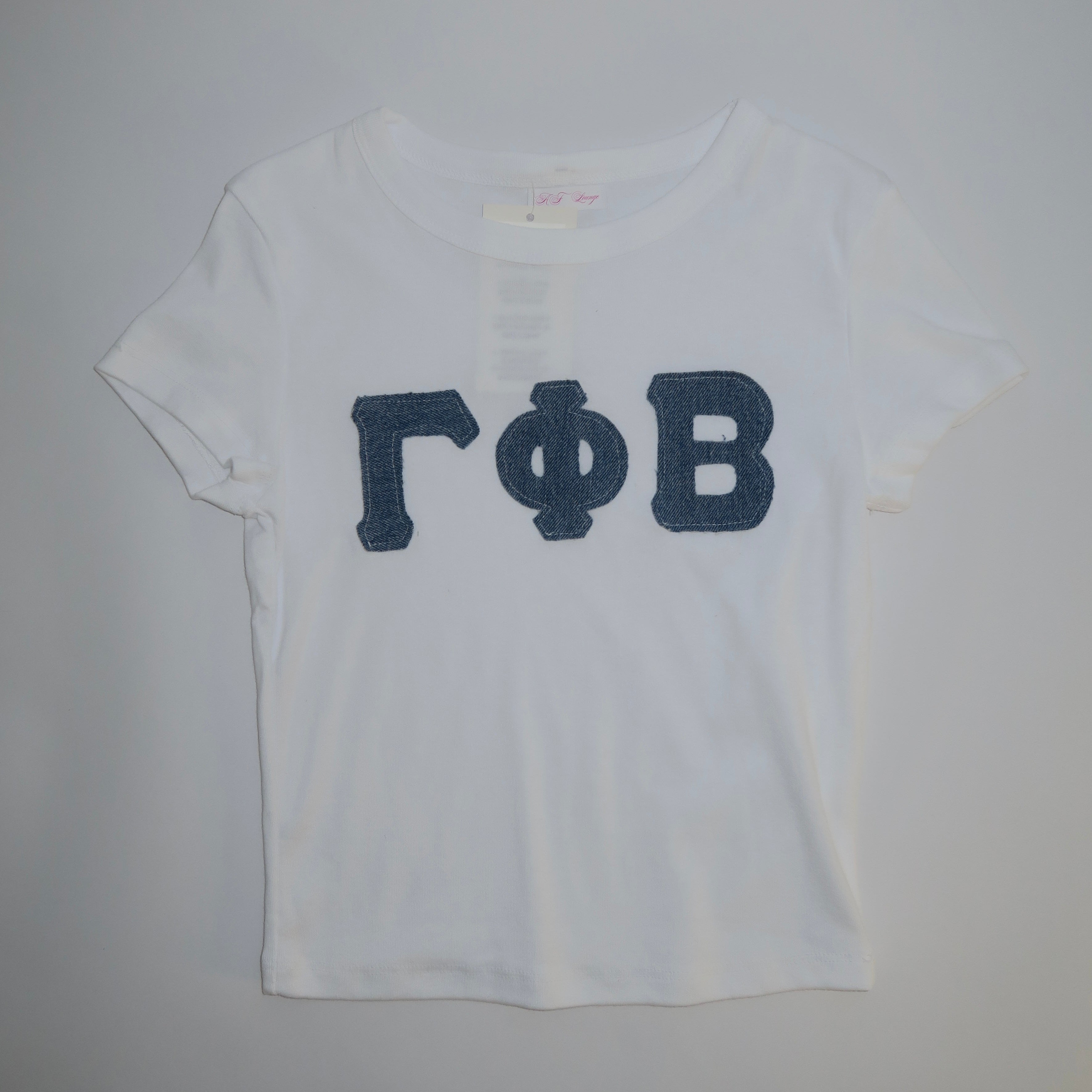 A white cotton baby tee with denim blue greek letters 'Gamma Phi Beta' printed on the front.